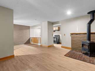 Cozy living space featuring a rustic brick fireplace with a wood-burning stove, perfect for chilly evenings.