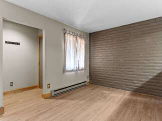 Discover a versatile living space featuring a unique textured brick accent wall, perfect for adding character to your home.