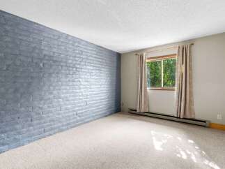 This room features a striking accent wall with a painted brick finish, adding a unique texture and modern aesthetic.