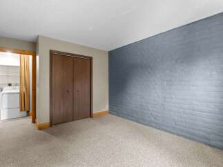 Discover the potential of this versatile space, featuring a convenient laundry area with a washer and dryer visible through an open doorway.