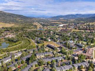 Discover this stunning aerial view of a vibrant community nestled amidst rolling hills and lush greenery.