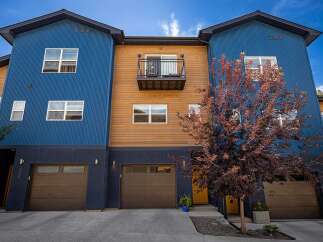 Discover modern living in this stunning townhouse featuring a striking blue and wood exterior.