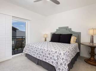 Experience comfort and style in this inviting bedroom, featuring a plush queen-size bed adorned with a charming floral duvet and elegant black throw pillows.