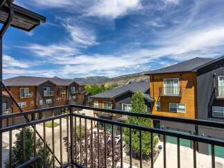 Experience modern living in this stunning townhome featuring a sleek exterior with warm wood accents and dark siding.