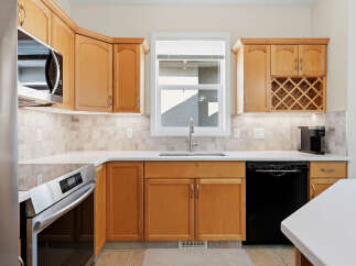 Discover this charming kitchen featuring light wood cabinetry and a sleek stainless steel microwave.