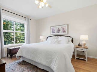 Experience comfort and style in this beautifully appointed bedroom, featuring a plush white duvet and a decorative ceiling fan.