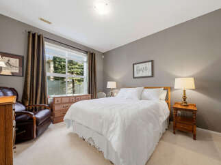 This inviting bedroom features a comfortable queen-size bed with crisp white linens, perfect for relaxation.