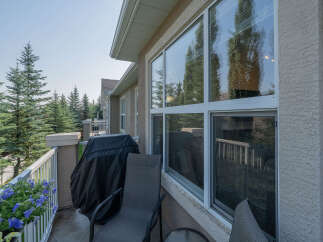 Enjoy outdoor living on this charming balcony, complete with a covered grill and comfortable seating.