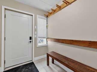 Welcome guests into this inviting entryway featuring a sleek white door with modern hardware.
