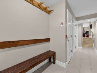 This hallway features a wooden bench and a coat rack, perfect for a mudroom or entryway.