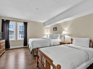 This inviting hotel room features two comfortable queen beds, perfect for families or groups traveling together.