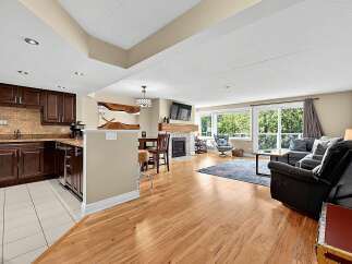 Experience modern living in this beautifully appointed condo, featuring a sleek kitchen with dark wood cabinetry and granite countertops.