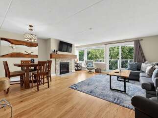Experience modern living in this spacious open-concept condo, featuring a cozy fireplace and a large dining area perfect for entertaining.