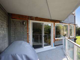 This property features a spacious balcony with a glass railing, offering a great outdoor living space.