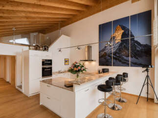 Experience modern living in this stunning open-plan kitchen and dining area, featuring sleek white cabinetry, a granite-topped island, and integrated appliances.