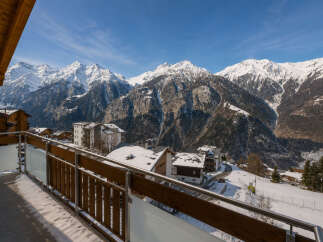 Experience breathtaking mountain views from this stunning property, featuring a spacious balcony perfect for enjoying the alpine scenery.