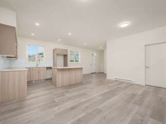 Discover modern living in this bright and airy open-concept space, featuring a sleek kitchen with ample cabinet storage and a central island perfect for meal prep and casual dining.