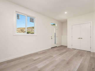Discover modern living in this bright and airy space, featuring a large window with scenic views and elegant light wood flooring throughout.