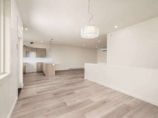 Discover modern living in this spacious open-concept home, featuring a sleek kitchen with a central island and ample cabinet space.