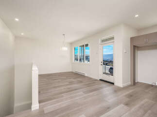 Experience modern living in this bright and airy open-concept space, featuring a stunning chandelier and large windows that flood the room with natural light.