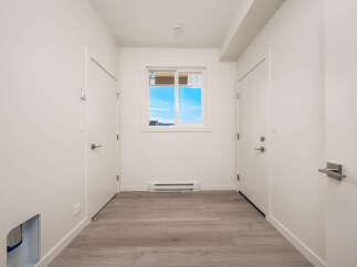 This hallway features a bright and airy atmosphere with clean white walls and modern finishes.