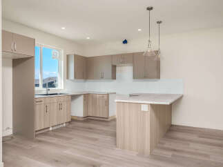 Discover this modern kitchen featuring sleek, dual-toned cabinetry and a spacious island perfect for meal prep and casual dining.