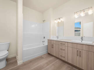 This modern bathroom features a spacious vanity with dual sinks and ample storage, perfect for any household.