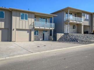 Discover modern living in these newly constructed townhomes, featuring sleek vertical siding and expansive balconies with glass railings.