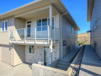 Discover modern living in this stunning townhouse featuring a sleek exterior with stone accents and a private balcony.
