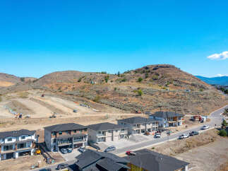 Discover this stunning new construction development nestled against a scenic hillside, offering a blend of modern homes and ongoing construction.