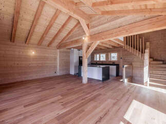 Experience rustic charm in this beautifully appointed wooden interior, featuring exposed beams and a warm, natural wood finish throughout.