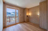 Experience breathtaking mountain views from this charming room featuring natural wood paneling and a spacious balcony.