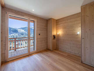 Experience breathtaking mountain views from this charming room featuring natural wood paneling and a spacious balcony.
