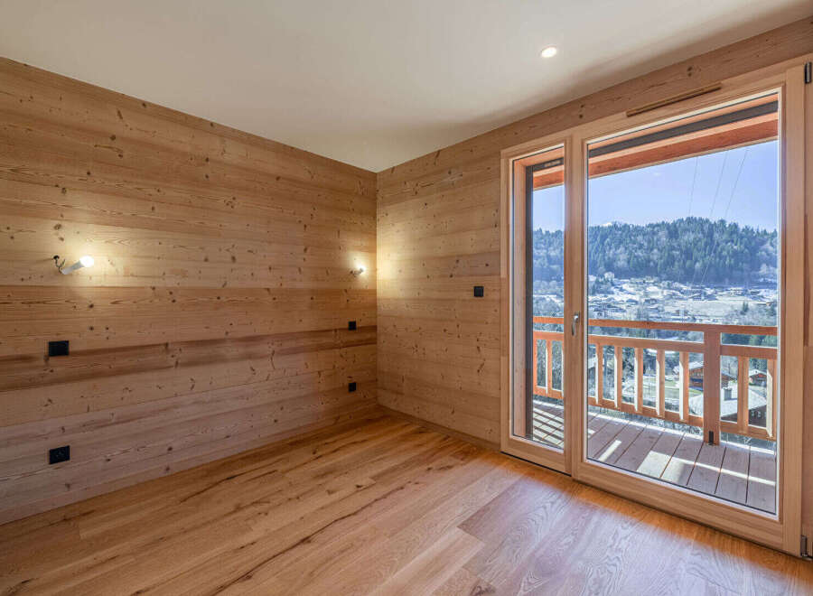 Experience breathtaking mountain views from this charming wooden-paneled room, featuring a spacious balcony perfect for enjoying the alpine scenery.