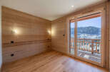 Experience breathtaking mountain views from this charming wooden-paneled room, featuring a spacious balcony perfect for enjoying the alpine scenery.