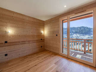 Experience breathtaking mountain views from this charming wooden-paneled room, featuring a spacious balcony perfect for enjoying the alpine scenery.