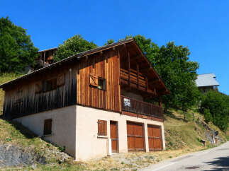 Discover this charming wooden chalet nestled on a hillside, offering a rustic mountain retreat.