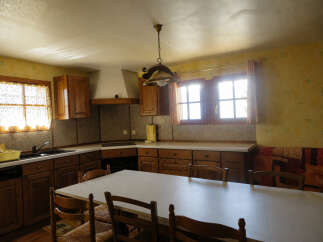 This charming kitchen features warm wooden cabinetry and a spacious dining area, perfect for family meals.