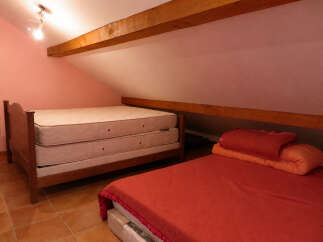 Discover this charming attic bedroom featuring two comfortable beds, perfect for accommodating guests or family.