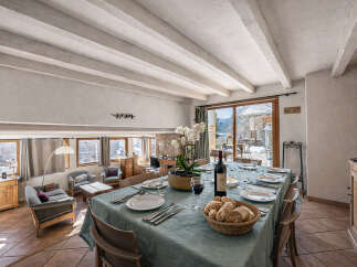 Experience elegant dining in this charming space, featuring a beautifully set table with a bottle of wine and fresh bread, ready for guests.