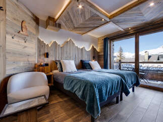 Experience alpine luxury in this charming ski chalet bedroom, featuring two cozy twin beds adorned with plush blue blankets.