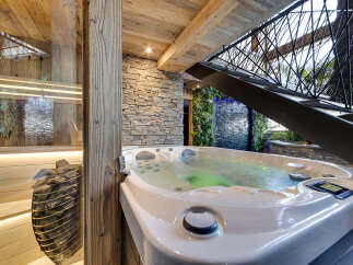 Indulge in ultimate relaxation with this luxurious spa retreat, featuring a bubbling hot tub and a serene sauna.