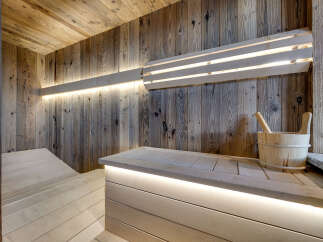 Experience ultimate relaxation in this luxurious wooden sauna, featuring ambient LED lighting that enhances the warm, natural wood tones.