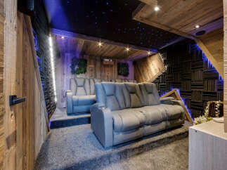 Experience ultimate relaxation in this luxurious home theater, featuring plush reclining seats and a stunning starry night ceiling.