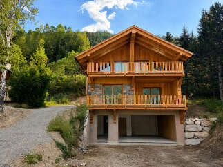 Discover this stunning wooden chalet nestled in a serene mountain landscape, perfect for a luxurious getaway.