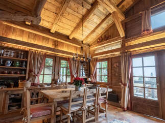 Experience rustic charm in this cozy dining area, featuring a large wooden table and chairs perfect for family gatherings.