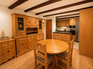 Experience rustic charm in this inviting dining area, featuring a beautiful wooden hutch and a round dining table perfect for family gatherings.
