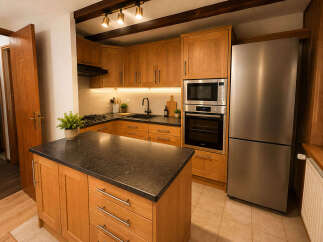 Discover this charming kitchen featuring warm oak cabinetry and a spacious island with a dark granite countertop, perfect for meal preparation and casual dining.