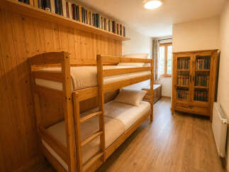 This charming bedroom features a space-saving wooden bunk bed, perfect for families or guests.