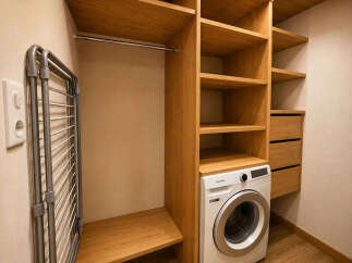 Discover this modern laundry room featuring a sleek Samsung washing machine and ample wooden shelving for storage.